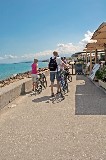 Turisti con la bicicletta  di fronte alla fila dei ristoranti vicini al porto.