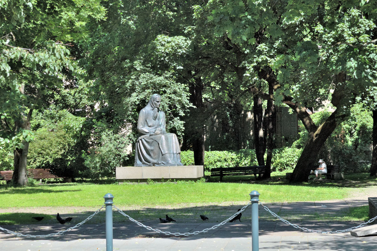 La statua di Julija 'emaitė sotto il sole, tra il verde.